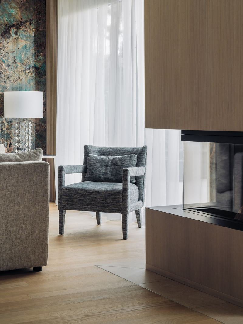 Habillage de cheminée en bois, fauteuil et parquet chêne