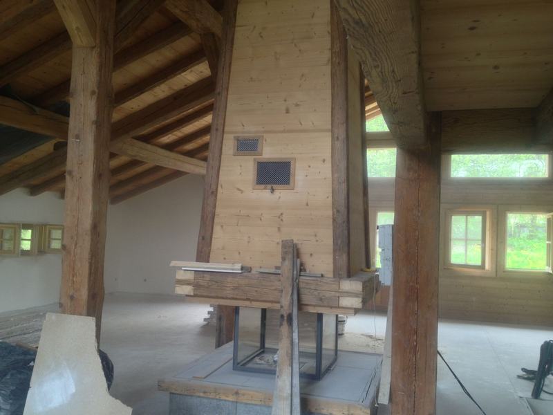 Chalet en chantier : poutres anciennes et habillage de cheminée en bois