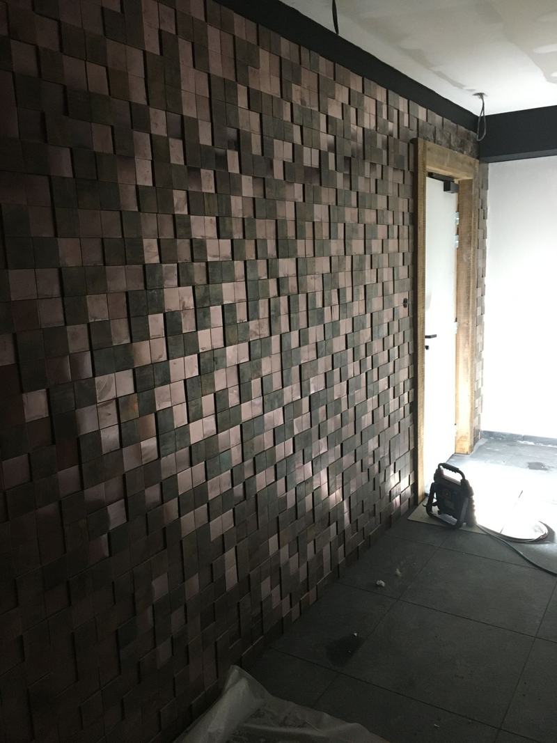 Mur sculpté composé de cubes de bois sombre en relief